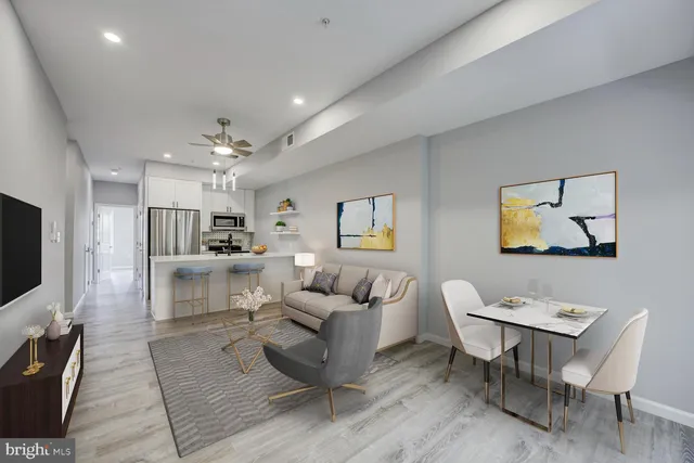 a living room with furniture a flat screen tv and kitchen view