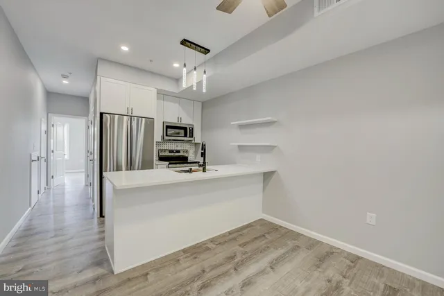 a view of kitchen with stainless steel appliances a refrigerator and a stove top oven