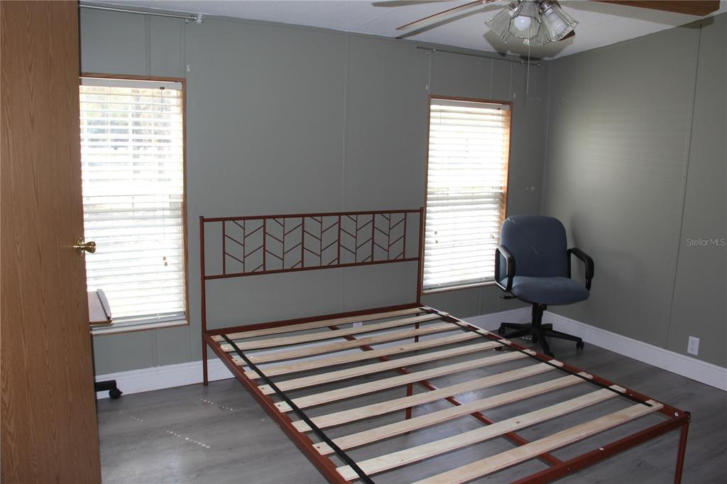 13201 Crowell Road Brooksville, FL 34613 - Photo 12 of 35 a bedroom with a window and a chair