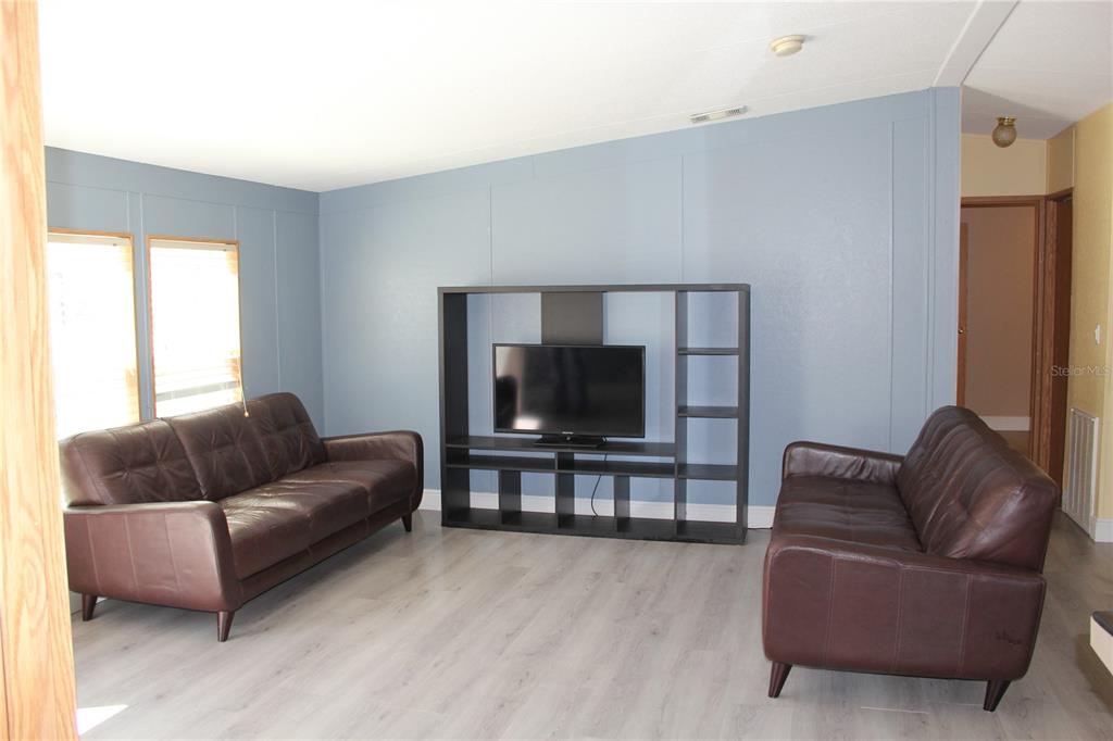 13201 Crowell Road Brooksville, FL 34613 - Photo 2 of 35 a living room with furniture and a flat screen tv