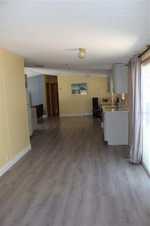 13201 Crowell Road Brooksville, FL 34613 - Photo 7 of 35 an empty room with furniture and wooden floor