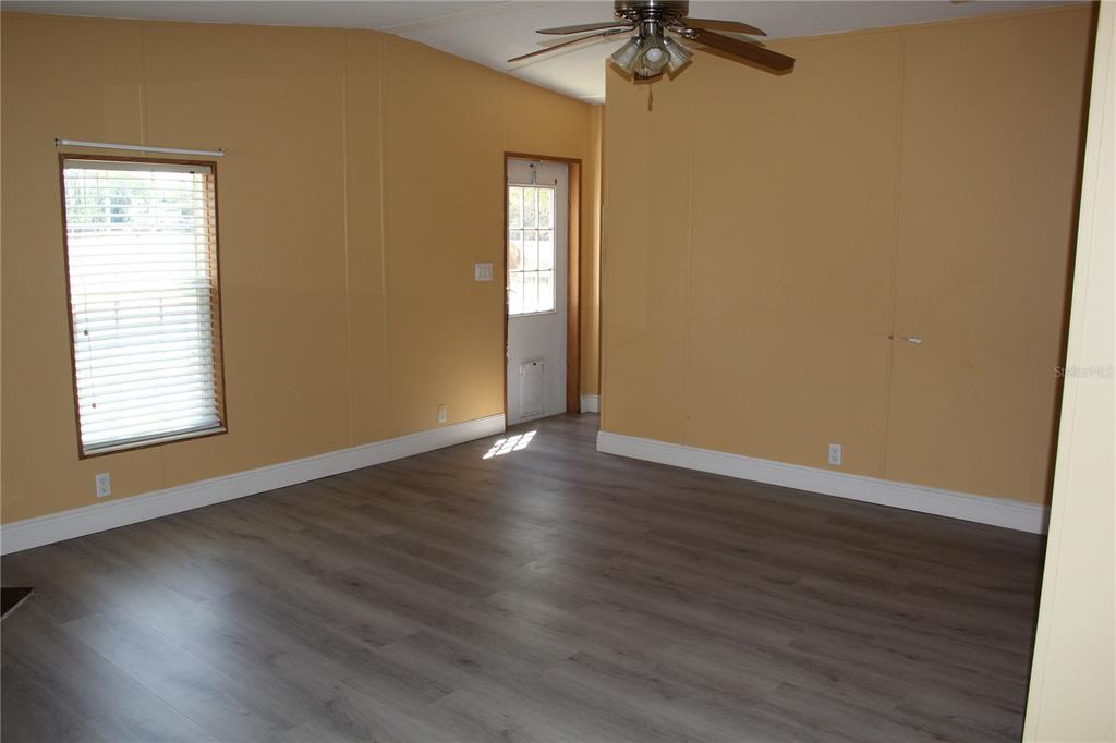 13201 Crowell Road Brooksville, FL 34613 - Photo 10 of 35 a view of an empty room with wooden floor and a window