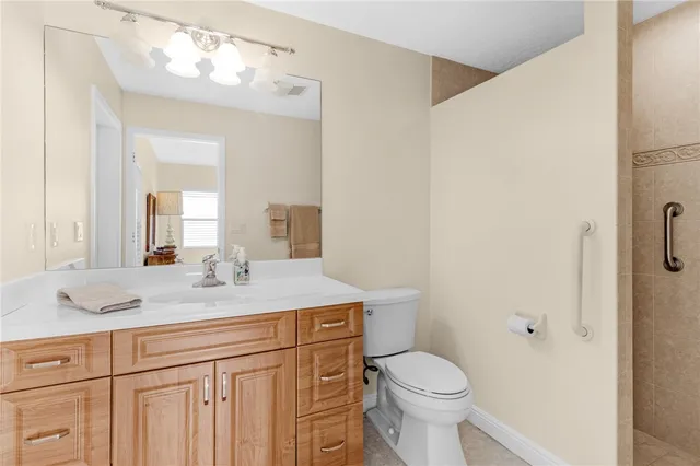 a bathroom with a granite countertop sink mirror vanity and toilet