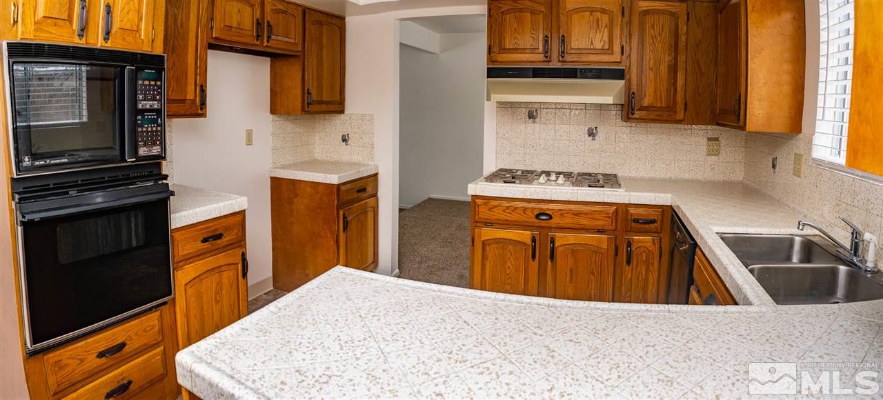 3255 Argo Way Reno, NV 89509 - Photo 14 of 25 a kitchen with stainless steel appliances granite countertop a stove a sink and a refrigerator