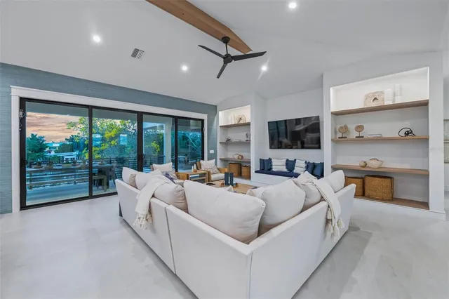 a kitchen with stainless steel appliances a refrigerator a sink a stove a dining table and chairs with wooden floor