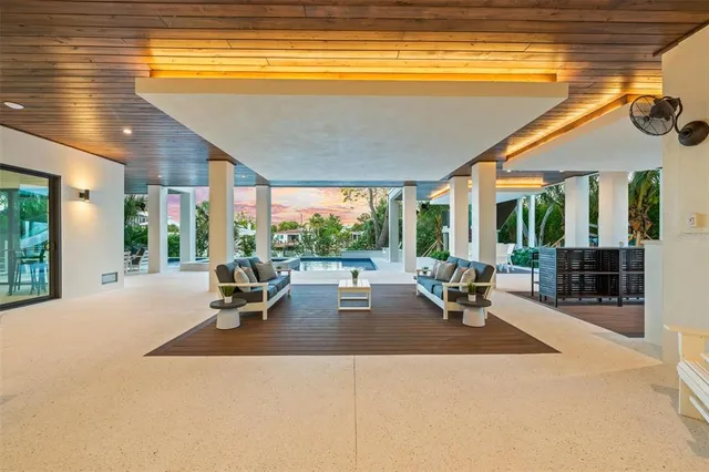 a living room with patio furniture and a large window