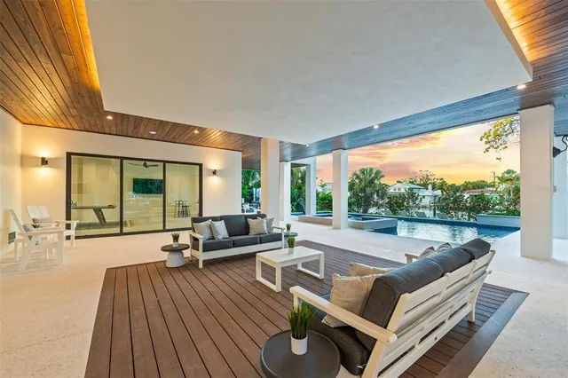 a patio with table and chairs and potted plants
