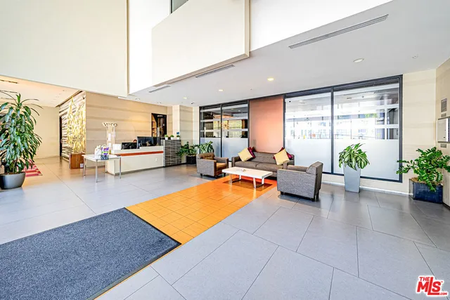 a living room with furniture pool table and potted plants
