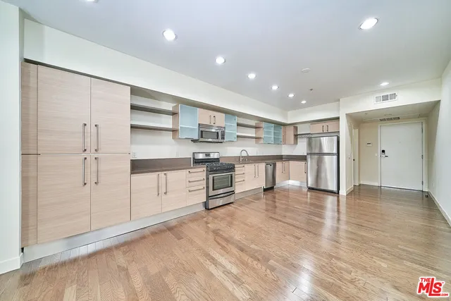 a view of kitchen with wooden floor and electronic appliances