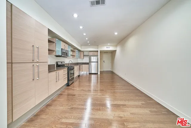 a kitchen with stainless steel appliances granite countertop a refrigerator and a stove top oven