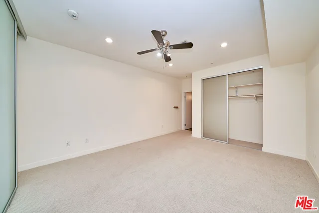 an empty room with a ceiling fan and window