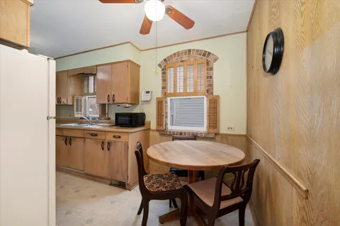 a dining room with wooden floor a chandelier a wooden table and chairs