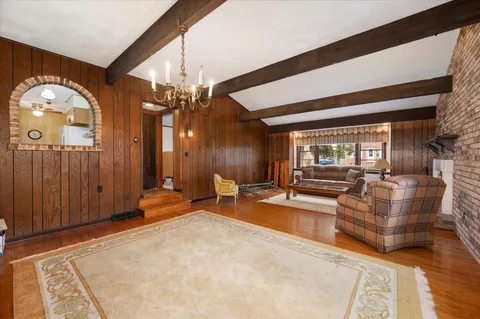 a living room with furniture a large window and potted plants