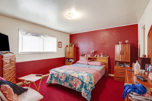 a bedroom with a bed and dresser with mirror