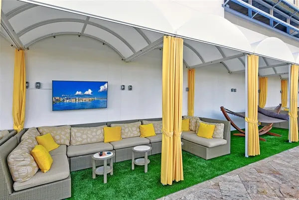 a view of a balcony with wooden floor and a palm tree