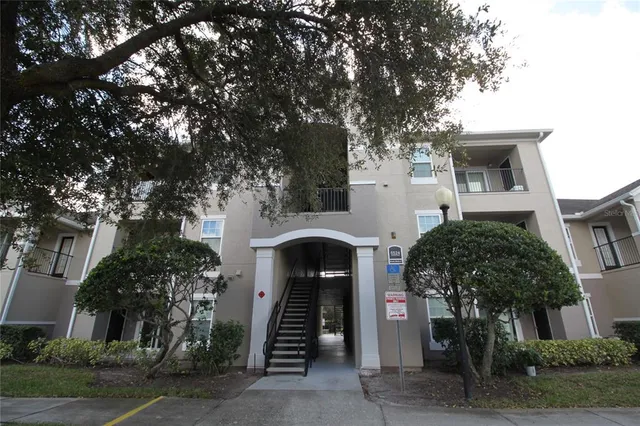 a front view of a house with a tree