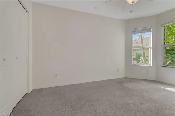 an empty room with windows and closet