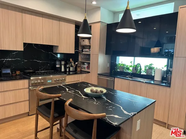 a kitchen with a sink a counter and chairs