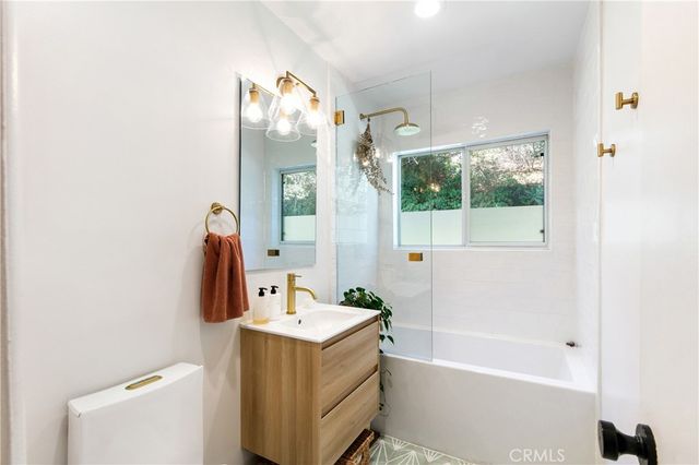 a bathroom with a tub sink and mirror