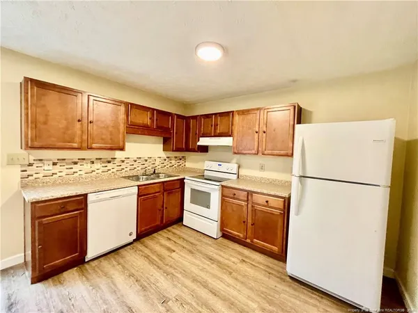 a kitchen with granite countertop appliances a sink and a refrigerator