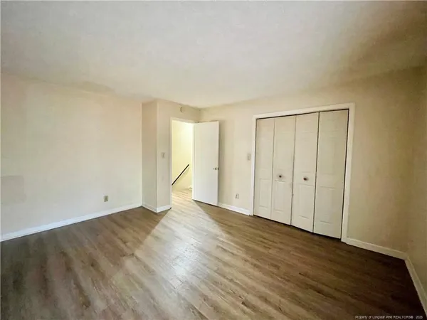 a view of an empty room with wooden floor