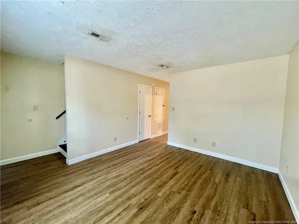 a view of an empty room with wooden floor