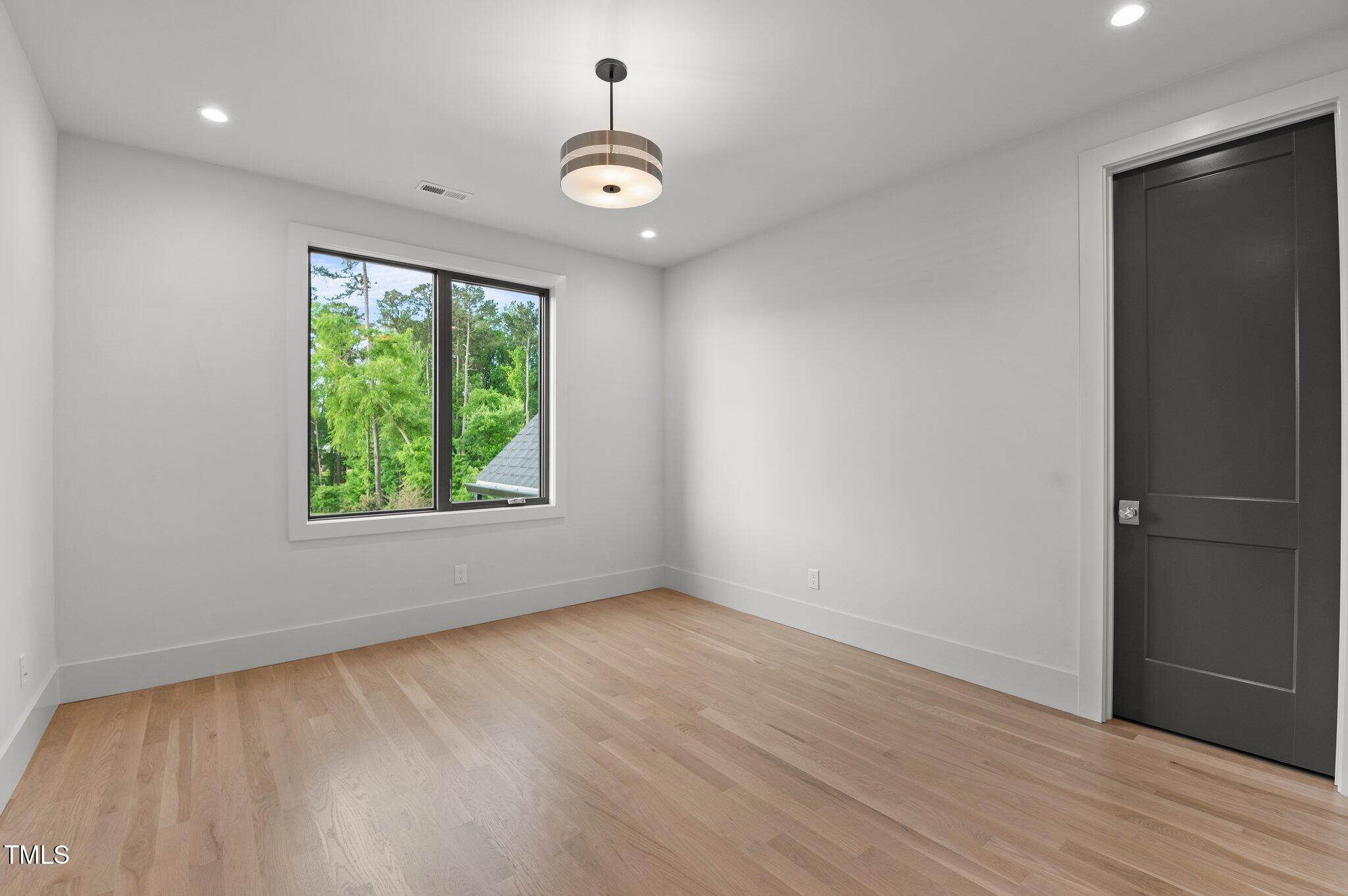 949 Harrison Ridge Road Wake Forest, NC 27587 - Photo 31 of 52 an empty room with wooden floor and windows