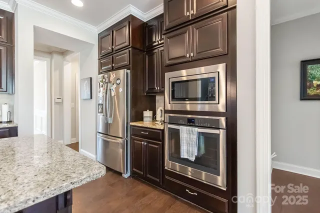 a kitchen with stainless steel appliances granite countertop a refrigerator and a stove