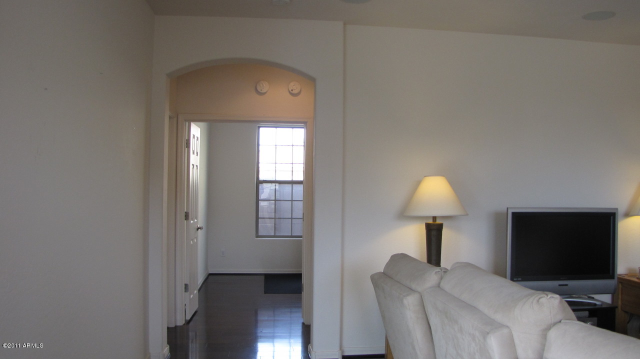 16007 West Pima Street Goodyear, AZ 85338 - Photo 18 of 35 a living room with furniture a lamp and a flat screen tv