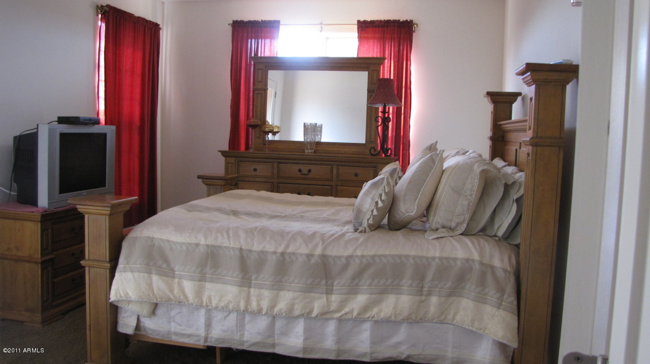 16007 West Pima Street Goodyear, AZ 85338 - Photo 19 of 35 a bedroom with a bed and a mirror