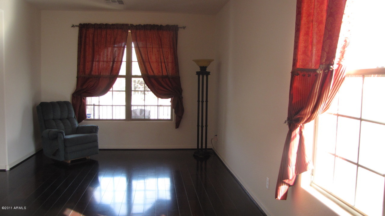 16007 West Pima Street Goodyear, AZ 85338 - Photo 4 of 35 a view of an empty room with wooden floor and windows