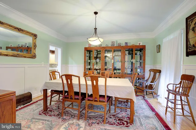 a dining room with furniture a chandelier and wooden floor