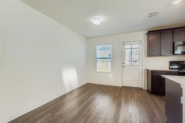a view of a kitchen with wooden floor and a window