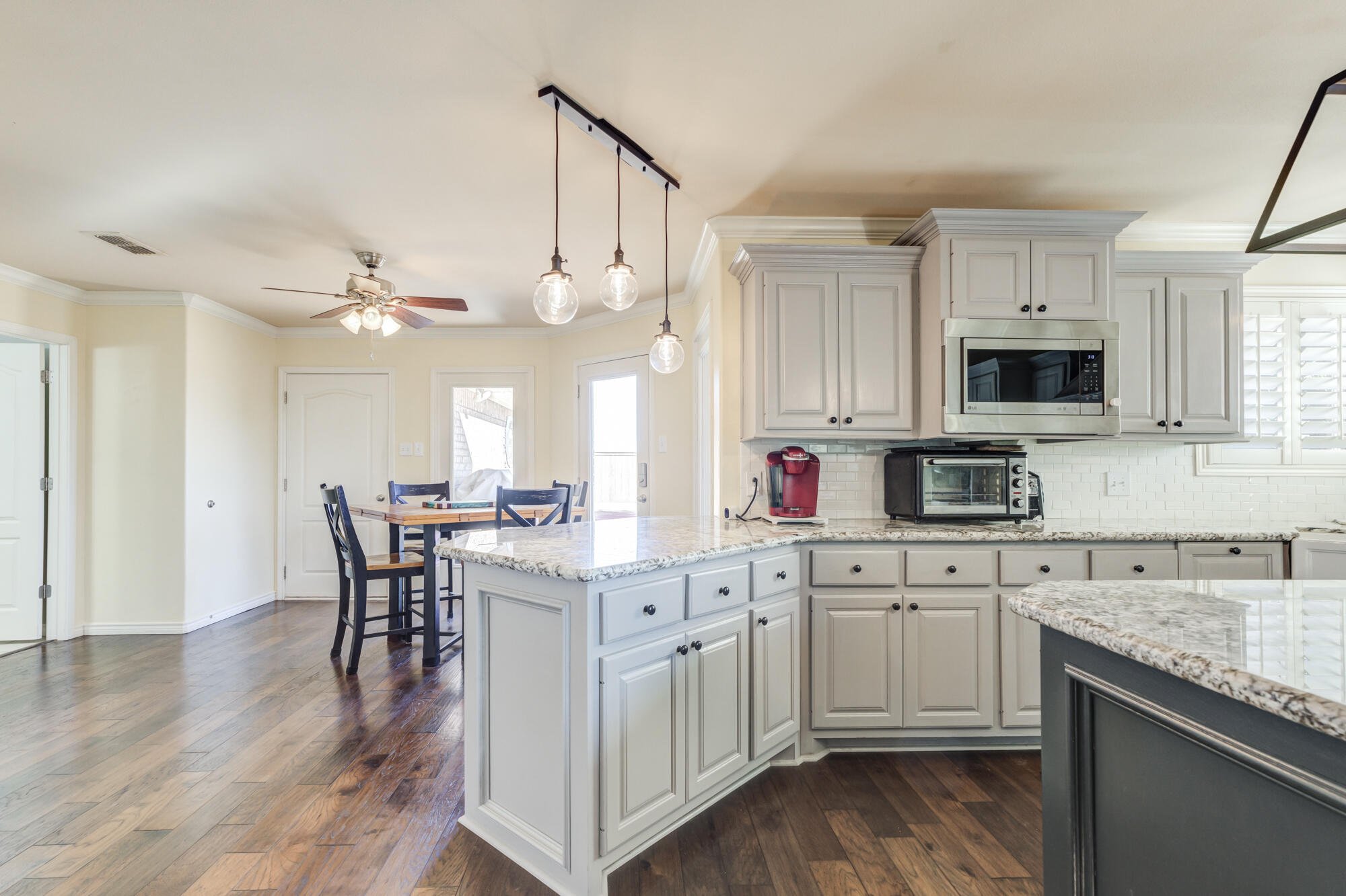 6302 County Road 7435 Lubbock, TX 79424 - Photo 14 of 59 a kitchen with a white cabinets and chairs in it