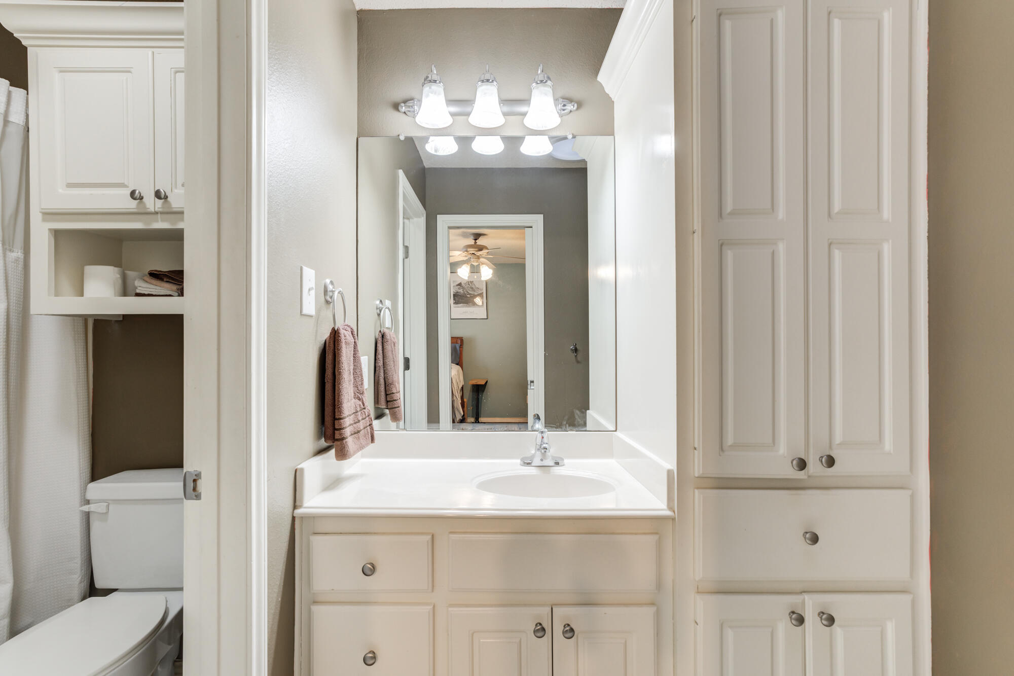 6302 County Road 7435 Lubbock, TX 79424 - Photo 34 of 59 a bathroom with a granite countertop sink a toilet and a mirror