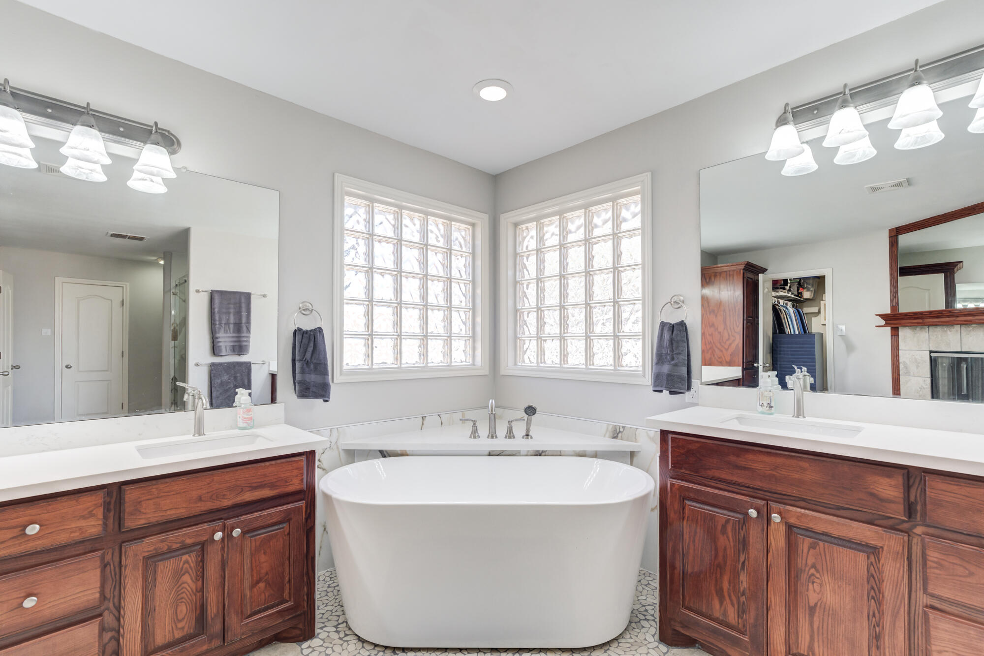 6302 County Road 7435 Lubbock, TX 79424 - Photo 41 of 59 a spacious bathroom with a double vanity sink a large mirror and a bathtub