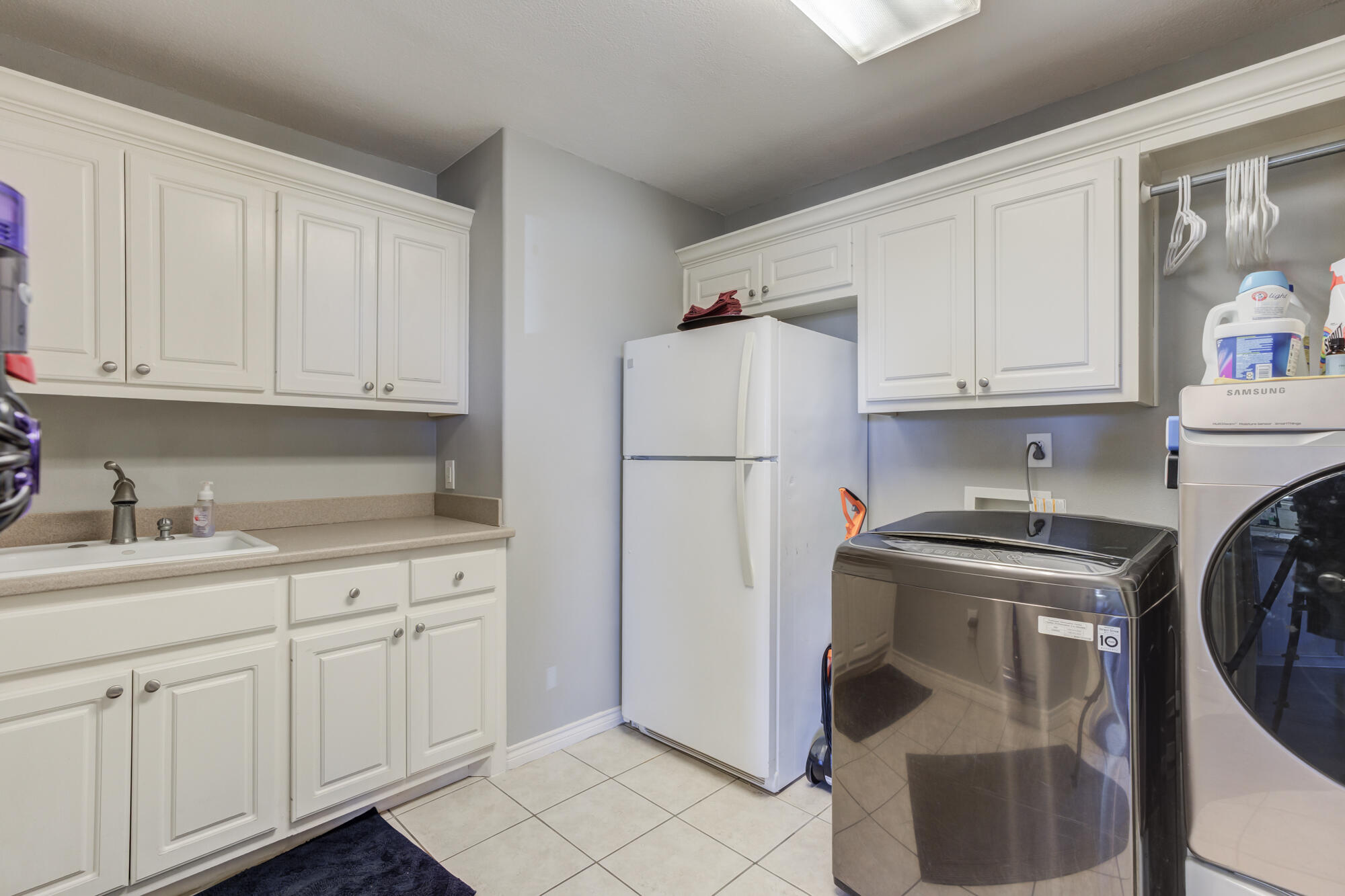 6302 County Road 7435 Lubbock, TX 79424 - Photo 46 of 59 a kitchen with stainless steel appliances granite countertop a refrigerator a stove a sink and white cabinets with wooden floor
