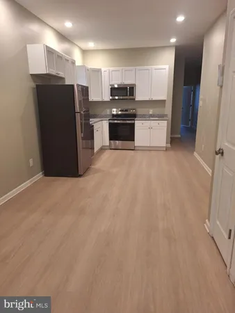 a kitchen with stainless steel appliances granite countertop a refrigerator and a stove top oven