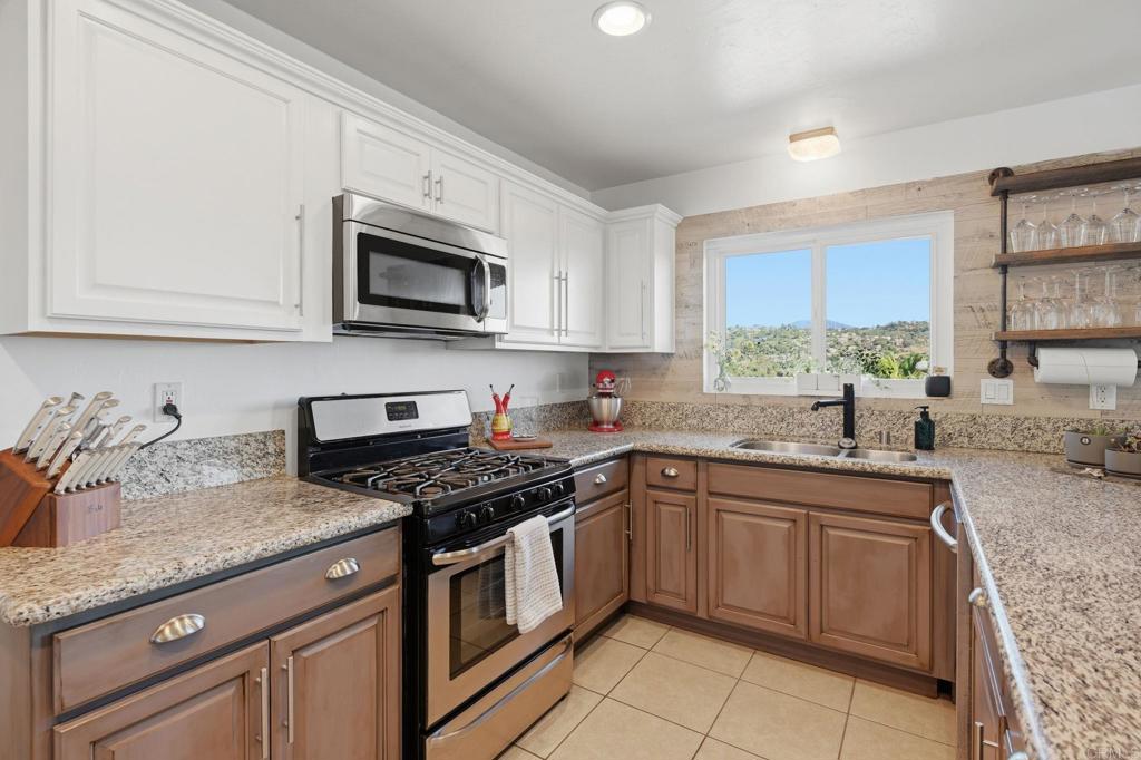 3328 Central Avenue Spring Valley, CA 91977 - Photo 7 of 54 a kitchen with granite countertop stainless steel appliances a sink cabinets and a window