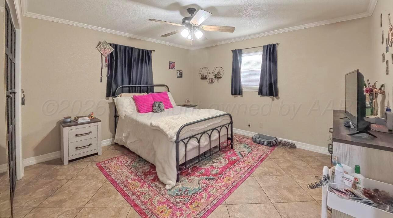 1402 Marigold Street Borger, TX 79007 - Photo 9 of 18 a bedroom with a bed dresser and a flat tv screen
