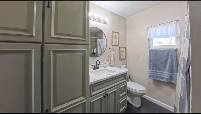 a bathroom with a toilet sink and mirror
