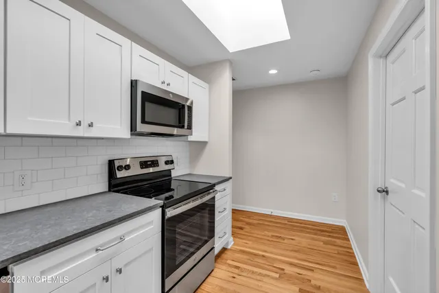 a kitchen with stainless steel appliances granite countertop a stove a microwave and a sink