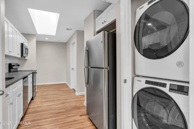 a view of a kitchen with stainless steel appliances granite countertop a refrigerator and a stove top oven