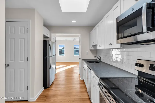 a kitchen with stainless steel appliances kitchen island granite countertop a stove and a microwave