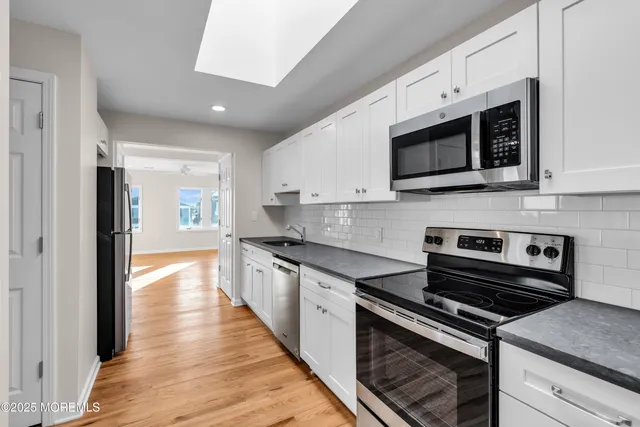 a kitchen with stainless steel appliances kitchen island granite countertop a stove microwave and sink