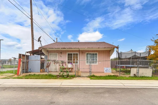 a front view of a house with a garden and plants