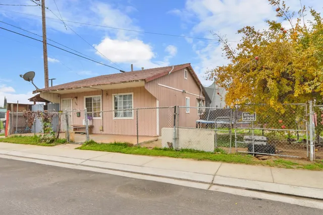 a front view of a house with a garden and plants