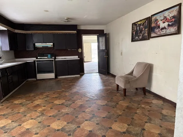 a living room with furniture a rug and kitchen view
