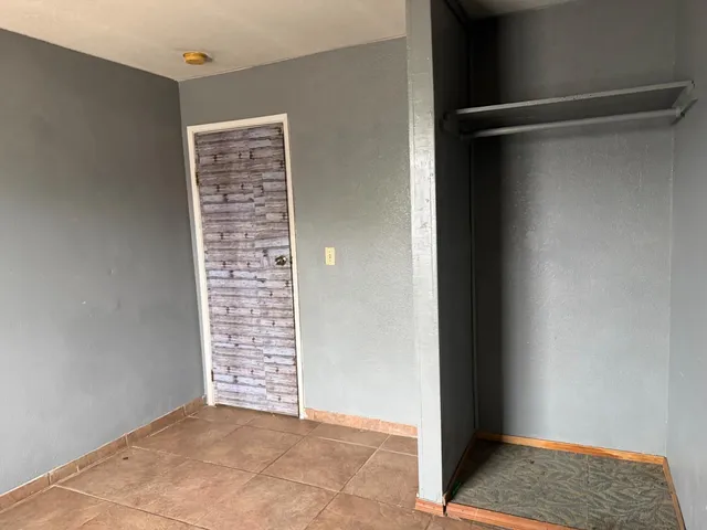 a view of a house with a floor to ceiling window and wooden fence