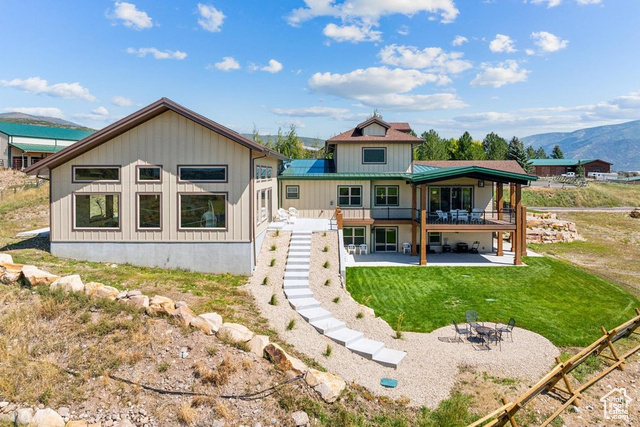 6117 North Rocky Ridge Road Peoa, UT 84061 - Photo 13 of 83 Rear view of house with a deck with mountain view, a lawn, and a patio area